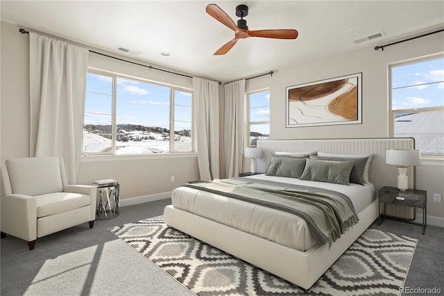 carpeted bedroom featuring multiple windows and ceiling fan