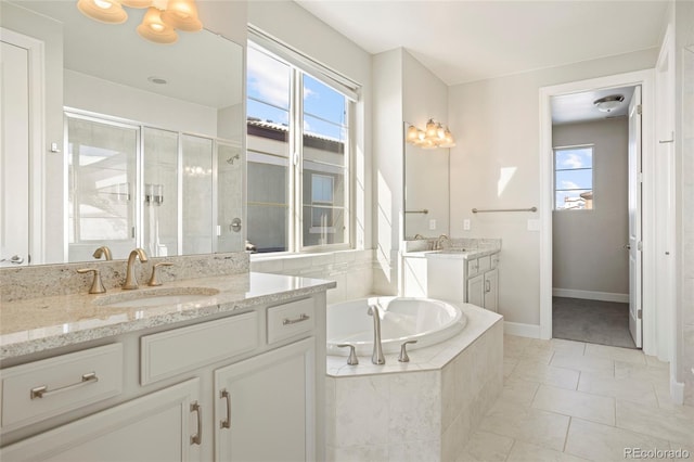 bathroom with tile patterned flooring, vanity, plus walk in shower, and a wealth of natural light