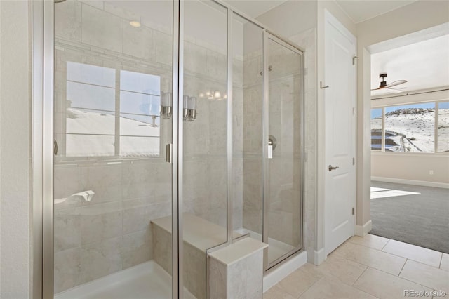 bathroom with ceiling fan, a shower with shower door, and tile patterned flooring