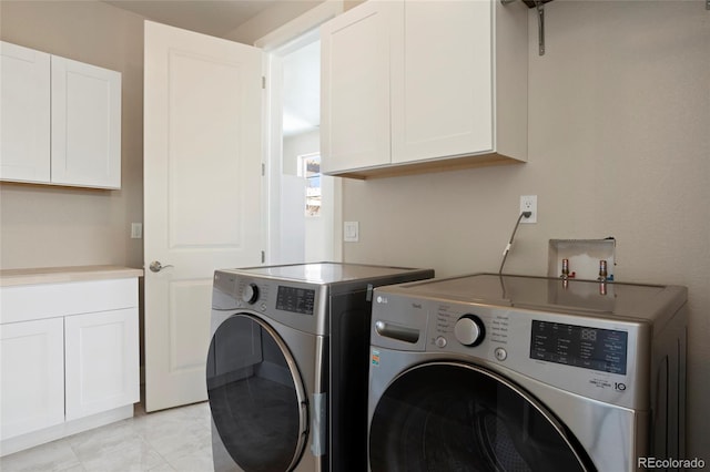 laundry room featuring cabinets and washer and dryer