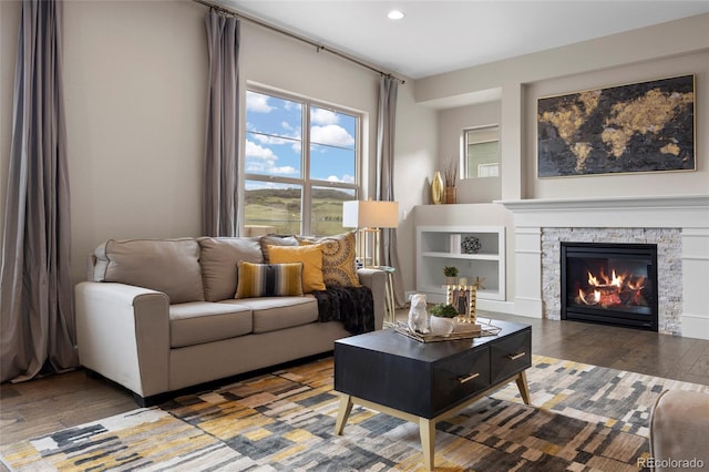 living area with wood finished floors, recessed lighting, and a fireplace