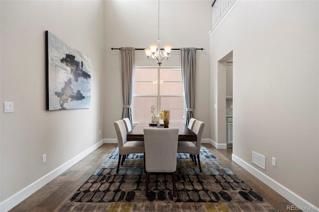 dining room with a chandelier, dark wood-style floors, and baseboards