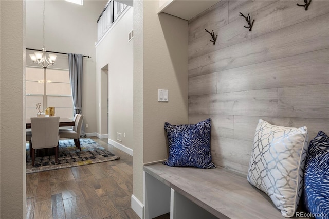 mudroom with a chandelier, wood finished floors, and baseboards