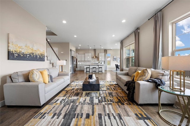 living room with wood finished floors, recessed lighting, stairs, plenty of natural light, and baseboards