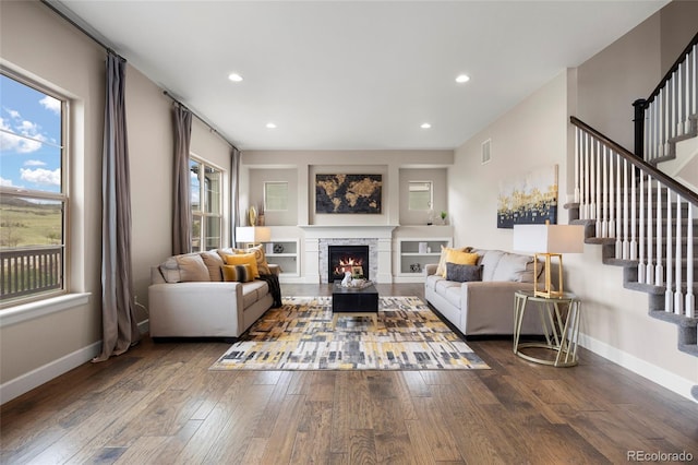 living area featuring hardwood / wood-style floors, stairs, baseboards, and recessed lighting