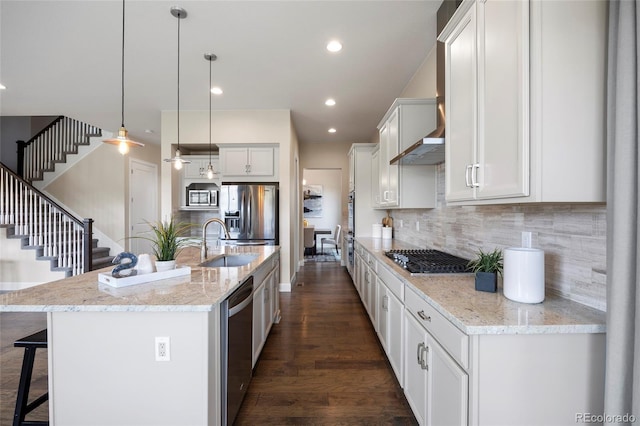 kitchen with appliances with stainless steel finishes, a sink, a kitchen breakfast bar, backsplash, and dark wood-style flooring