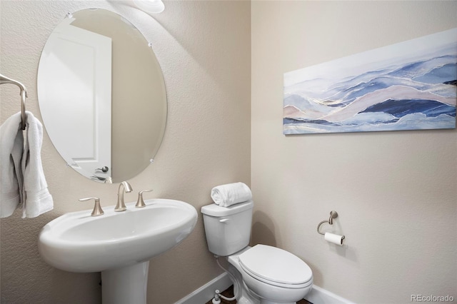 half bathroom with toilet and a sink