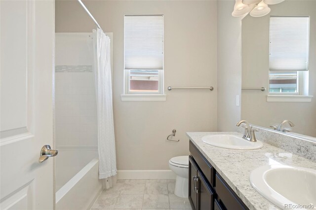 bathroom featuring toilet, double vanity, baseboards, and shower / bath combo with shower curtain