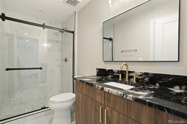 full bathroom with marble finish floors, a marble finish shower, toilet, and vanity