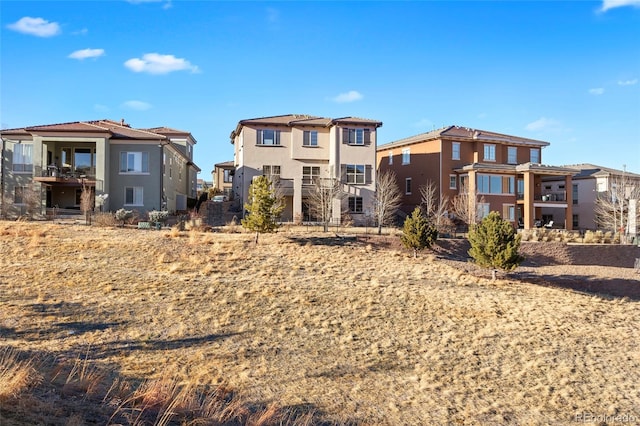 rear view of house featuring a residential view and stucco siding