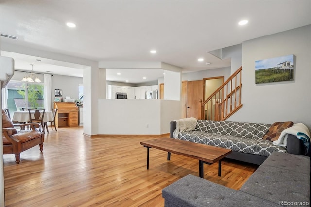 living room featuring stairway, light wood finished floors, visible vents, and recessed lighting