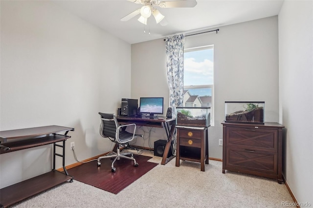carpeted home office featuring baseboards and a ceiling fan