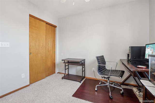 carpeted office featuring baseboards and a ceiling fan