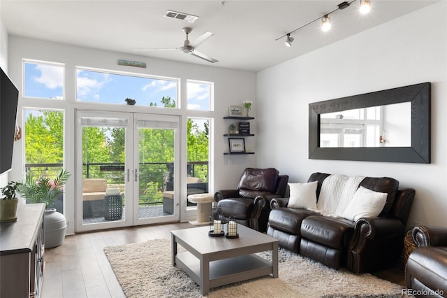 living room with ceiling fan, track lighting, light wood-type flooring, and french doors