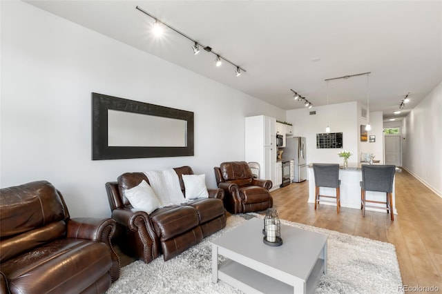living room with track lighting and light wood-type flooring