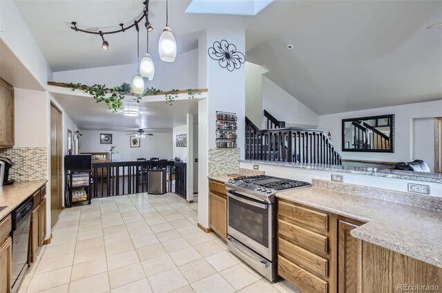 kitchen featuring ceiling fan, dishwasher, stainless steel range with gas cooktop, lofted ceiling with skylight, and decorative light fixtures