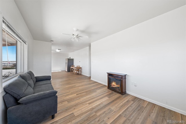 living room with light hardwood / wood-style flooring and ceiling fan