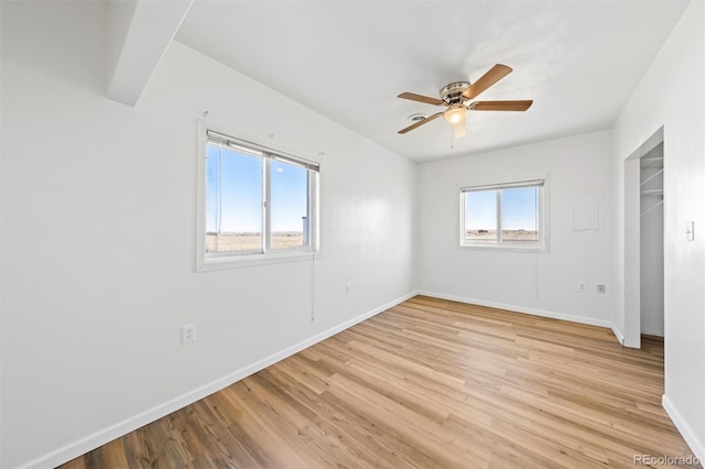 unfurnished room featuring light hardwood / wood-style floors, ceiling fan, and plenty of natural light