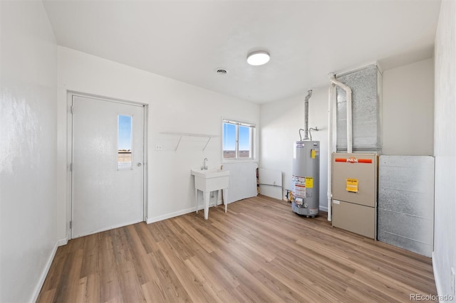 utility room with water heater and sink