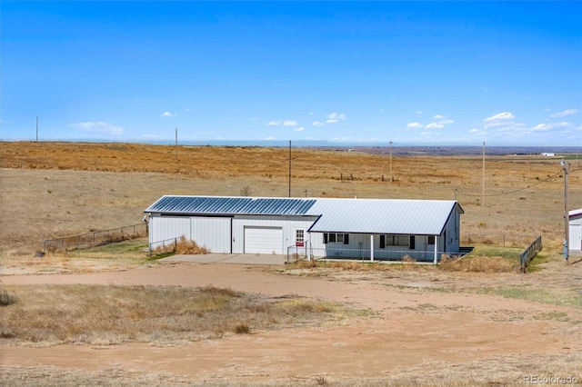 view of front of property featuring a rural view, an outdoor structure, and a garage