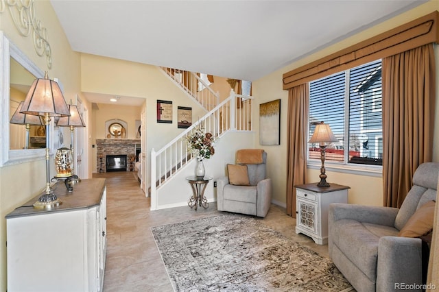 living area with a glass covered fireplace and stairs