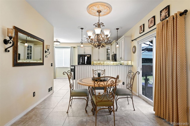 dining space featuring visible vents, a notable chandelier, light tile patterned flooring, and baseboards