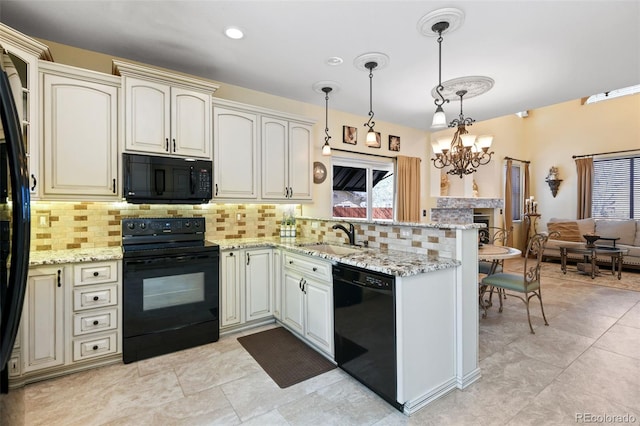 kitchen with black appliances, a sink, tasteful backsplash, cream cabinets, and a peninsula