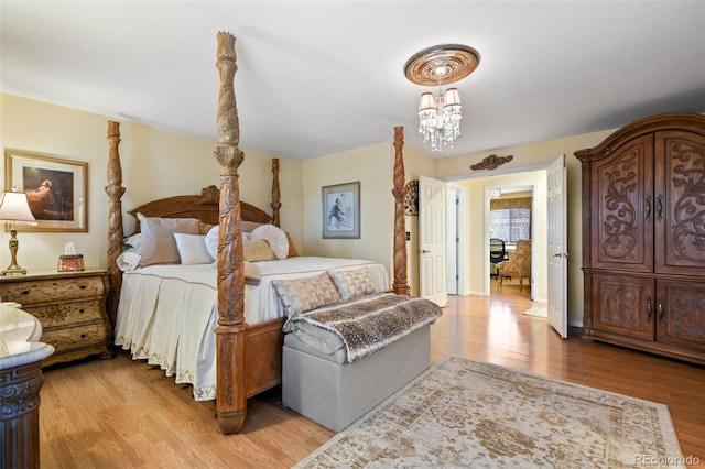 bedroom featuring light wood finished floors and a chandelier