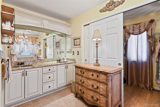 bathroom with a sink, a notable chandelier, and double vanity