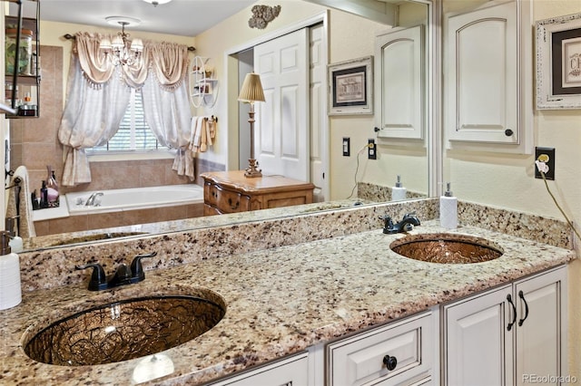 full bath with a sink, a chandelier, double vanity, and a tub