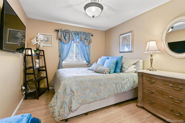 bedroom with light wood-style flooring and baseboards