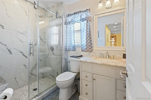 bathroom featuring a marble finish shower, toilet, and vanity