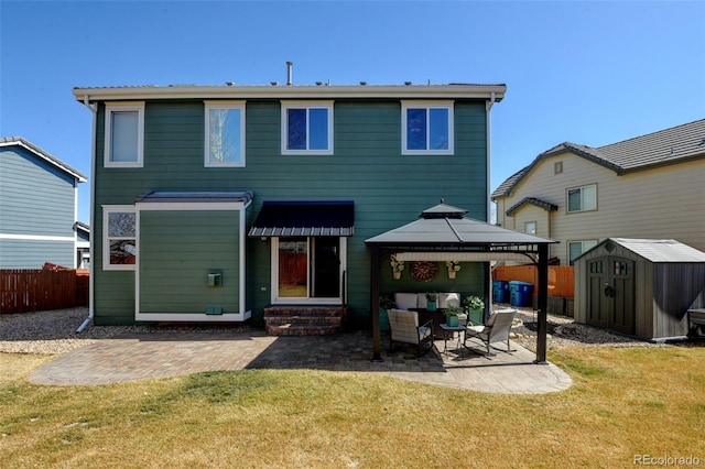 back of property with fence, entry steps, an outdoor structure, a patio area, and a storage unit