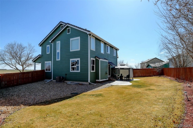 back of property featuring a fenced backyard, a yard, central AC, and a patio