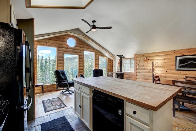 kitchen with light hardwood / wood-style floors, a healthy amount of sunlight, black appliances, and vaulted ceiling