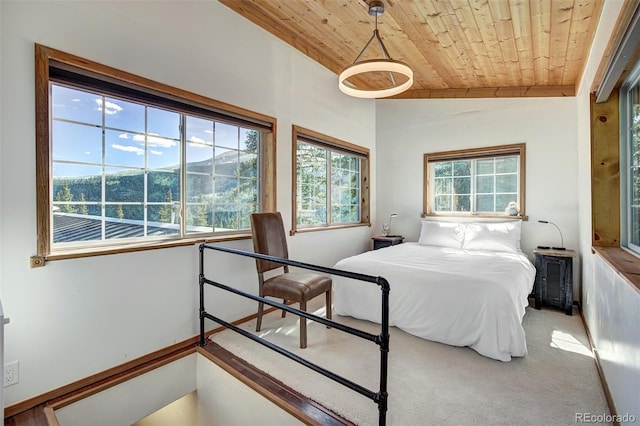 carpeted bedroom with a mountain view, wooden ceiling, and vaulted ceiling