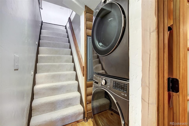 clothes washing area featuring stacked washer / dryer and light wood-type flooring