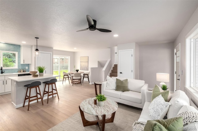 1011 Yeager Dr, Longmont, CO 80501 - living room featuring ceiling fan, recessed lighting, light wood-style floors, and stairway