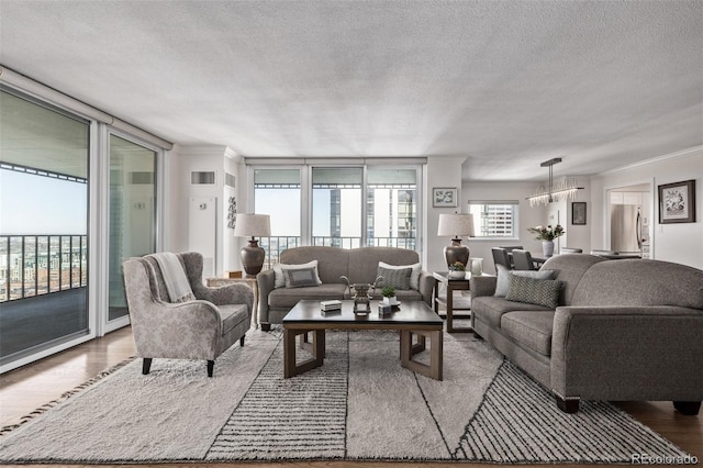 living room with floor to ceiling windows, hardwood / wood-style floors, and a textured ceiling