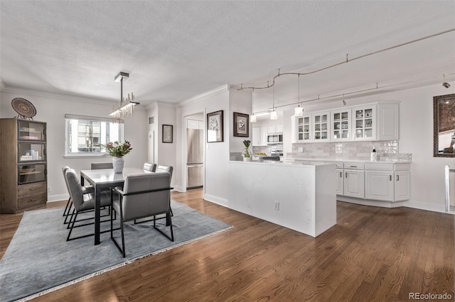 dining space featuring crown molding, dark wood-type flooring, and a textured ceiling