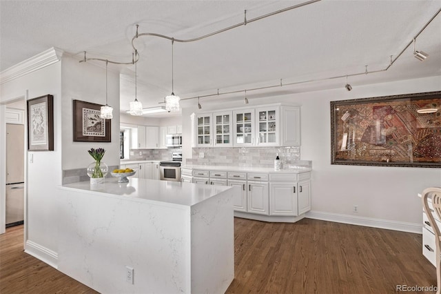 kitchen featuring decorative light fixtures, white cabinetry, backsplash, dark hardwood / wood-style flooring, and stainless steel appliances