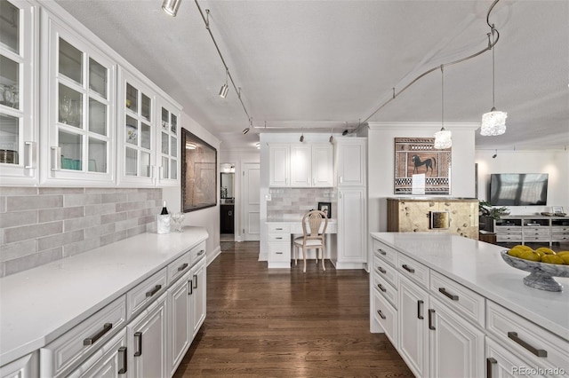 kitchen featuring tasteful backsplash, decorative light fixtures, dark wood-type flooring, and white cabinets