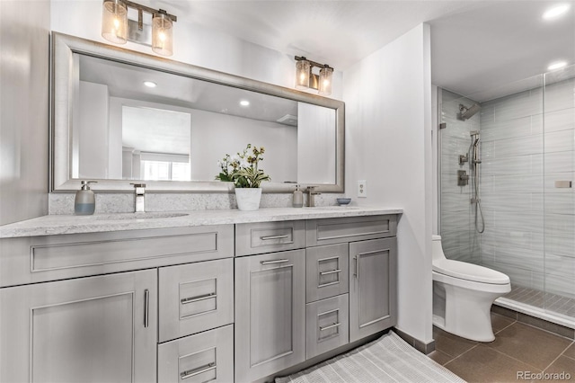 bathroom featuring vanity, toilet, tile patterned flooring, and a shower with door