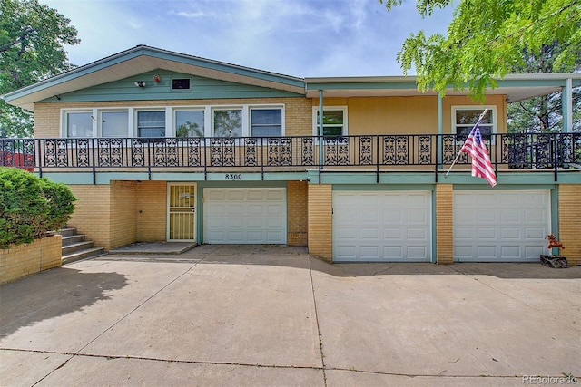 8300 W 67th Ave, Arvada, CO 80004 - view of front of home featuring concrete driveway, brick siding, and a garage