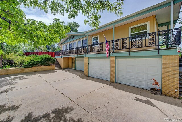 8300 W 67th Ave, Arvada, CO 80004 - multi unit property featuring brick siding, an attached garage, stairway, and driveway