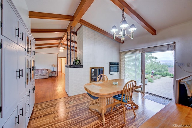 8300 W 67th Ave, Arvada, CO 80004 - dining area with light wood finished floors, a chandelier, and a fireplace