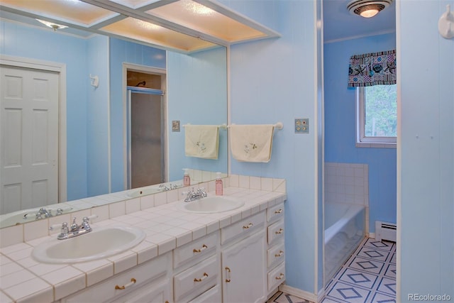 8300 W 67th Ave, Arvada, CO 80004 - bathroom featuring double vanity, baseboard heating, a garden tub, ornamental molding, and a shower with door