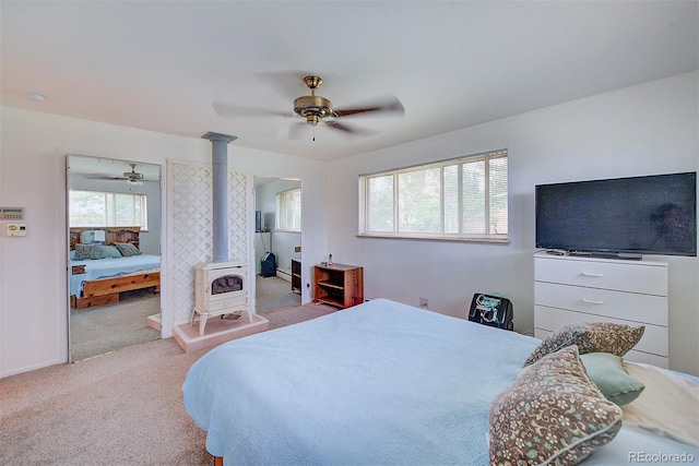 8300 W 67th Ave, Arvada, CO 80004 - bedroom featuring a wood stove, carpet flooring, and a ceiling fan