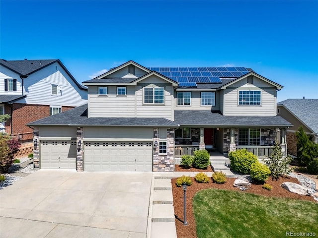 22227 E Hinsdale Ave, Aurora, CO 80016 - view of front of home featuring covered porch, driveway, roof mounted solar panels, a garage, and stone siding