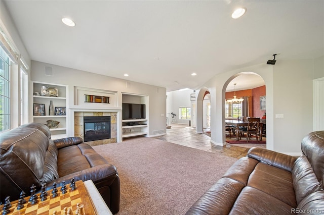22227 E Hinsdale Ave, Aurora, CO 80016 - living room featuring arched walkways, light tile patterned floors, recessed lighting, baseboards, and a tiled fireplace